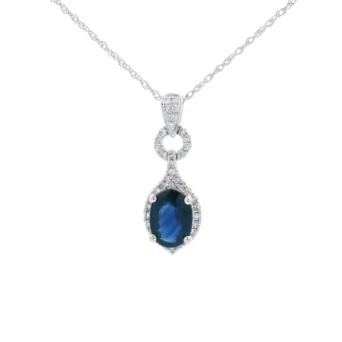 Elegant 10k white gold pendant with oval 7x5 blue sapphire and 1/6 diamond halo tw accents.